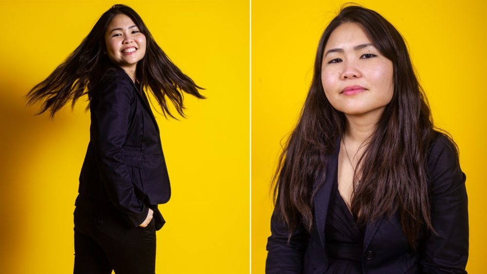 Two images of Tran next to each other. Wearing all black against yellow background. Left image she stands and twirls head with hair moving, right image is a headshot
